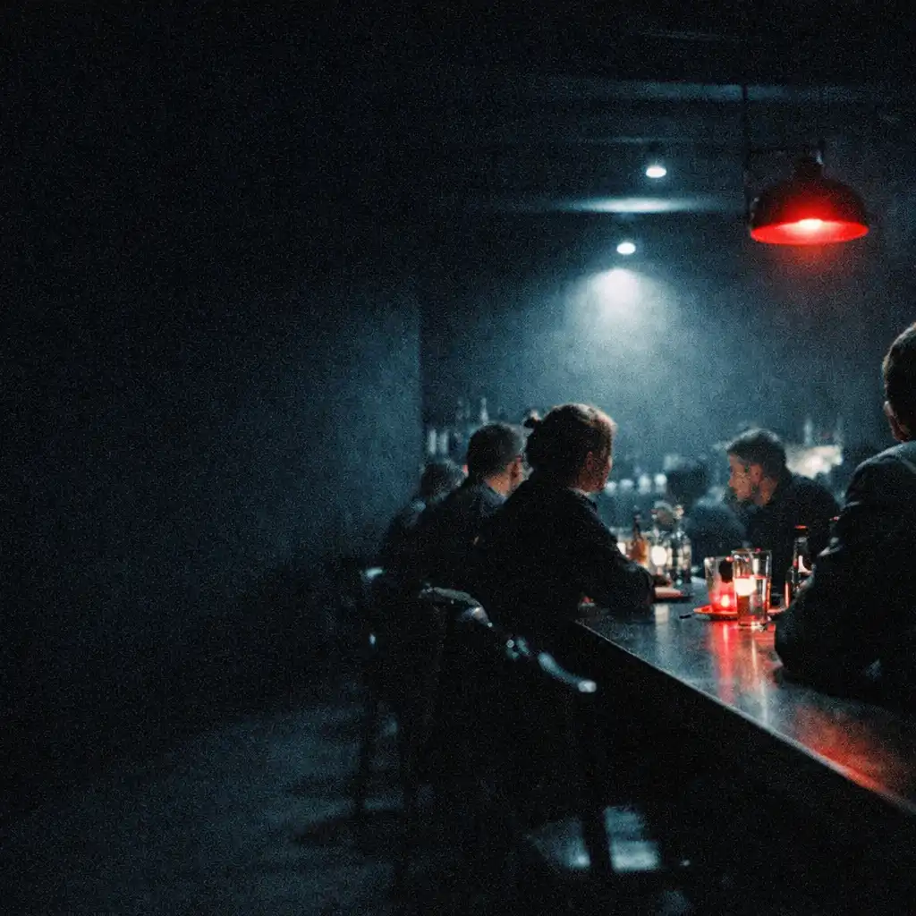 Późnonocna sala Restauracji Zunavesro z długim stołem, sylwetkami gości i czerwonym refleksiem światła